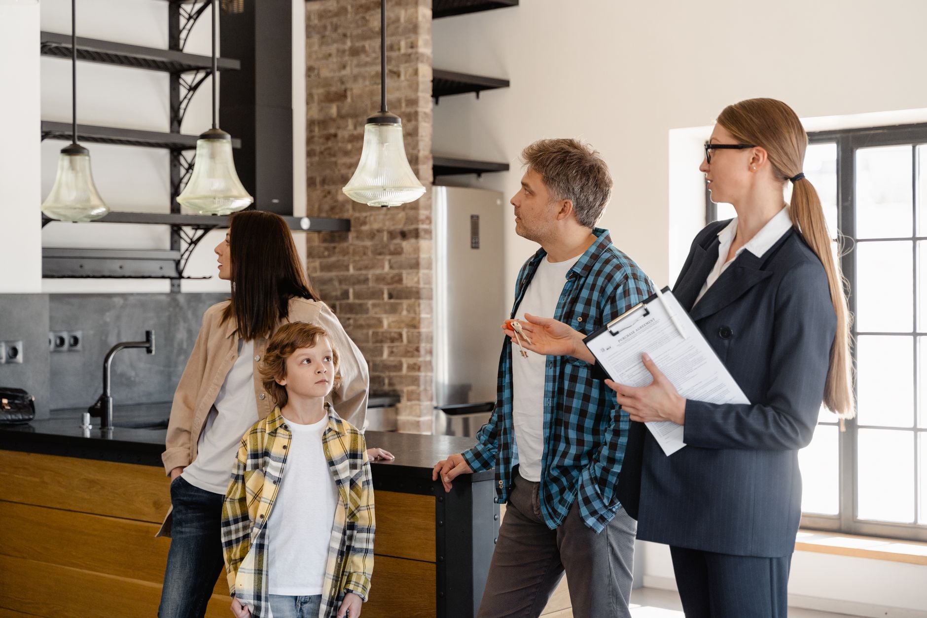 A realtor shows a property to a senior couple in a modern indoor setting.